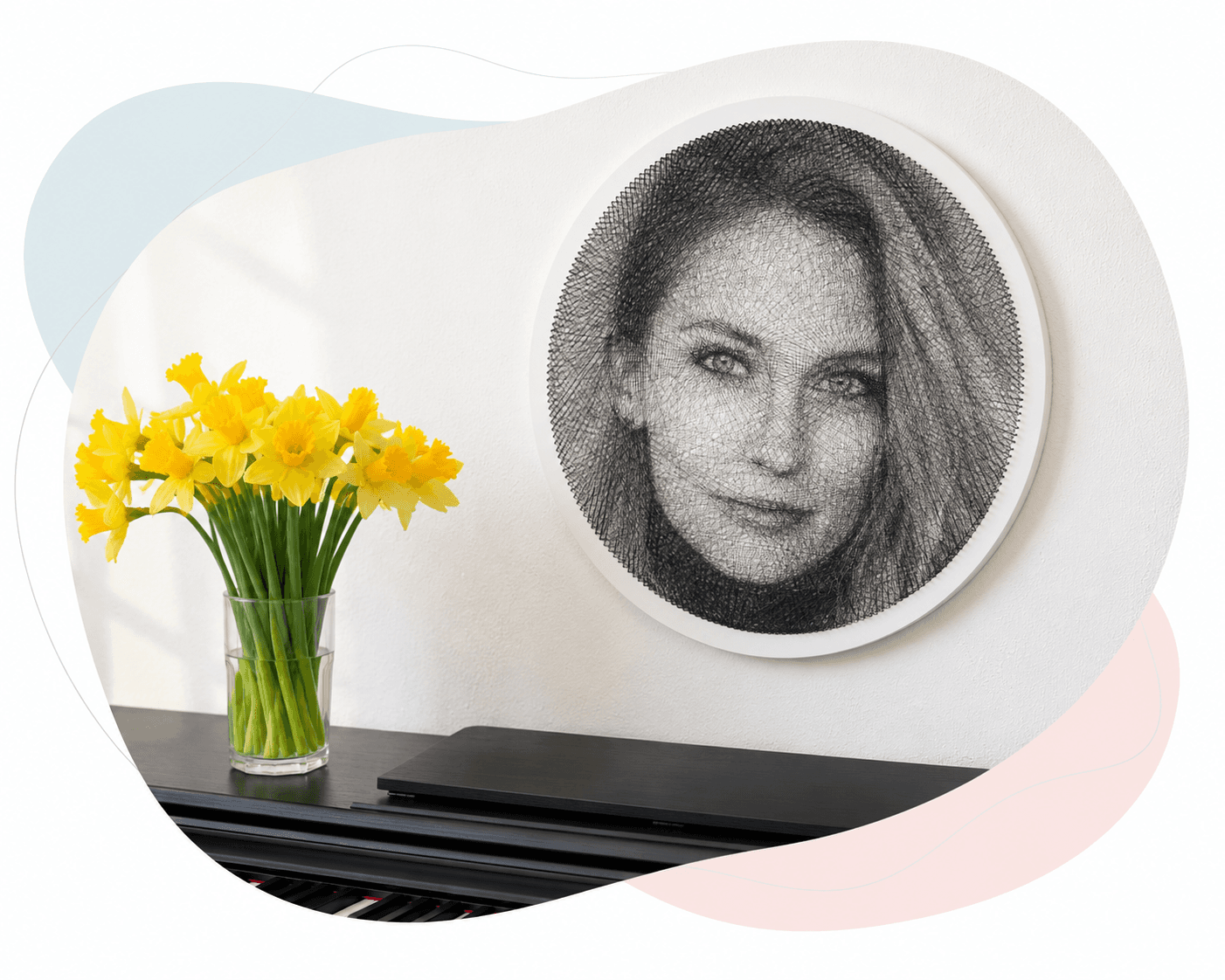 String art portrait displayed above yellow flowers on a piano
